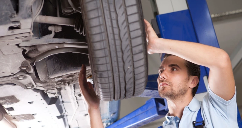 auto mechanic inspecting tire