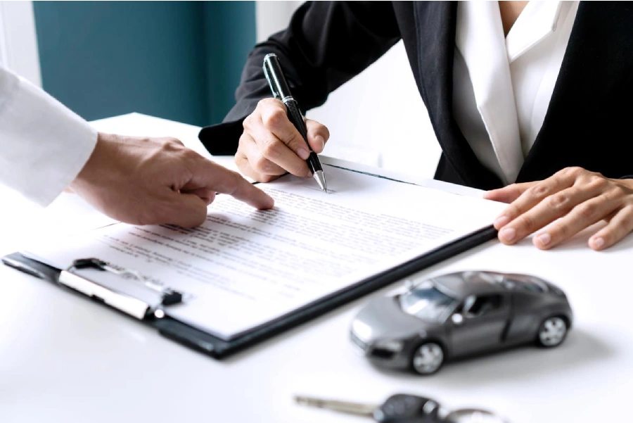 female signing car insurance documents
