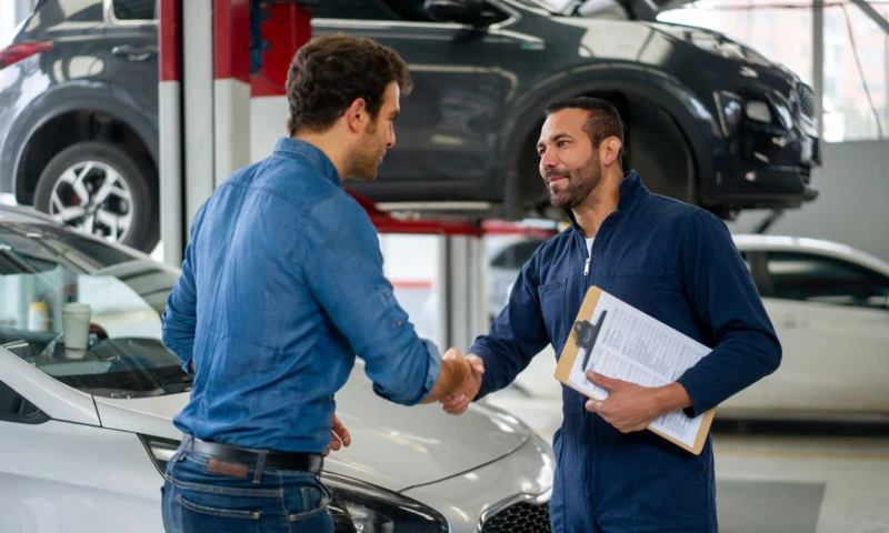 Man greeting handshake with car mechanic