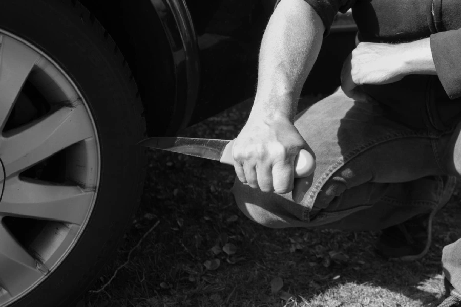 stabbing knife into car tire to slash the tire quickly